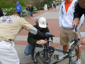 photo of partners pumping tires and installing lights for a UD student