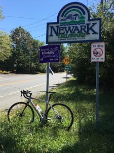 photo of bicycle under Newark, Delaware, and Bicycle Friendly Community signs