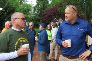The two men talking with others in the background.