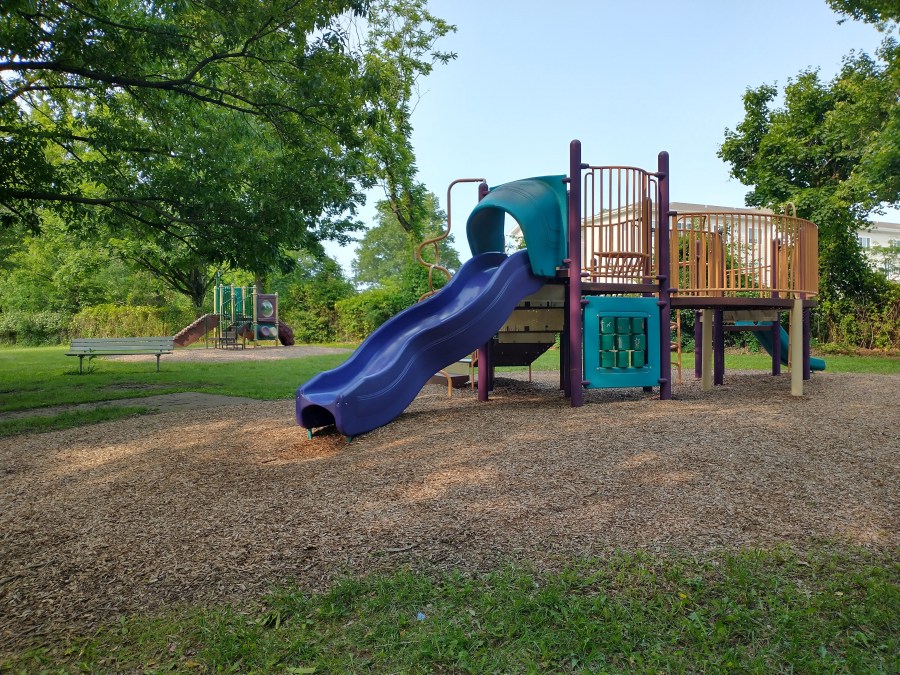 Two play structures, each with multiple slides, at Norma B. Handloff Park. No people are visible.