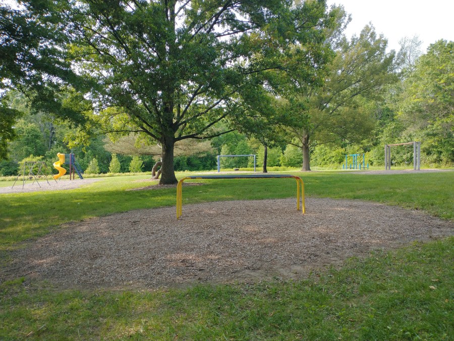 A slide, two swing sets, a tire swing, and other small play features at Norma B. Handloff Park.
